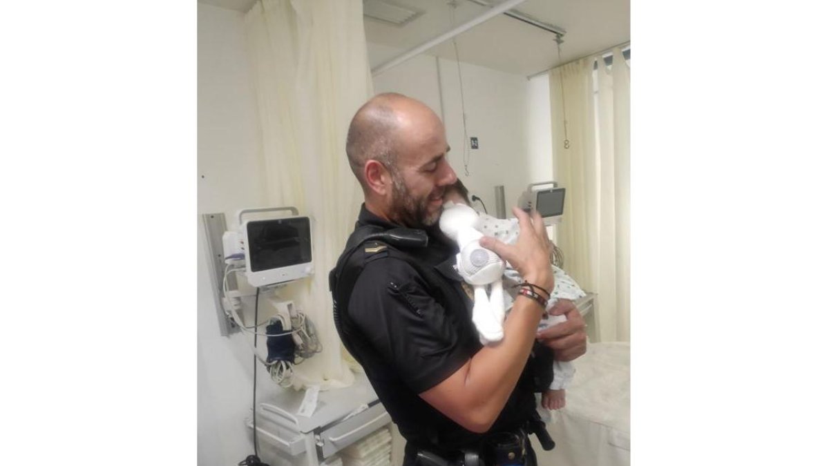 Agente de la Policía Nacional en Ávila calma a un bebé con el biberón.- TWITTER POLICIA