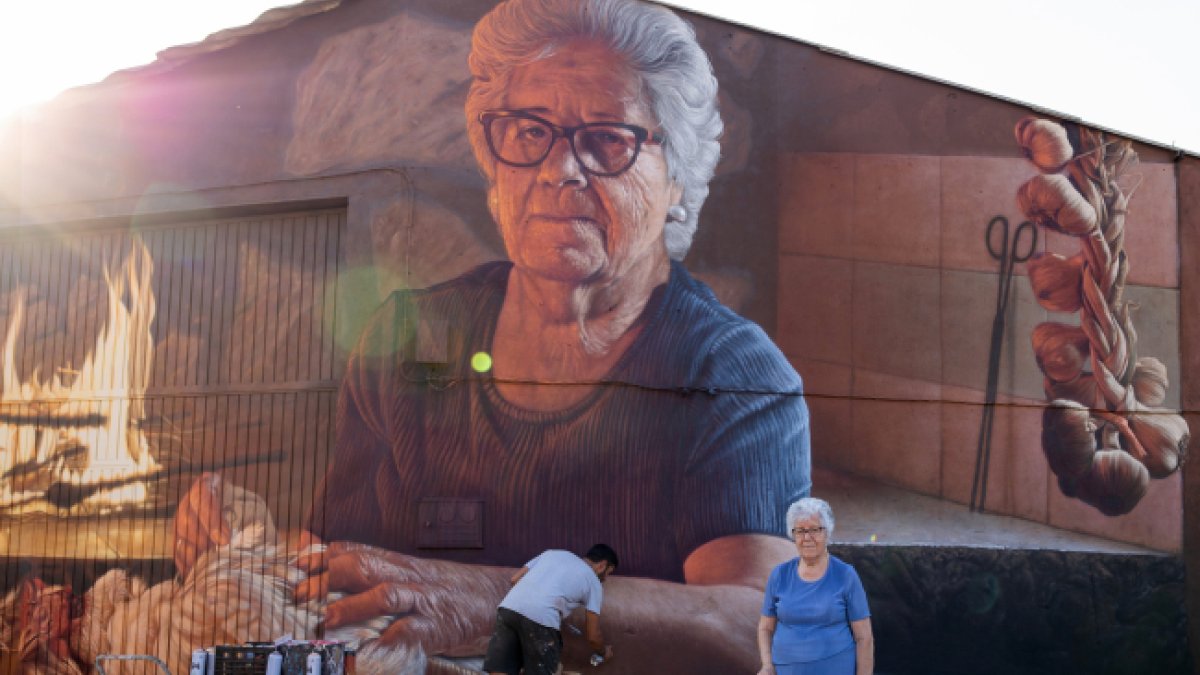 Christian Sasa trabaja en el mural con su protagonista delante. LUCAS MATÉ