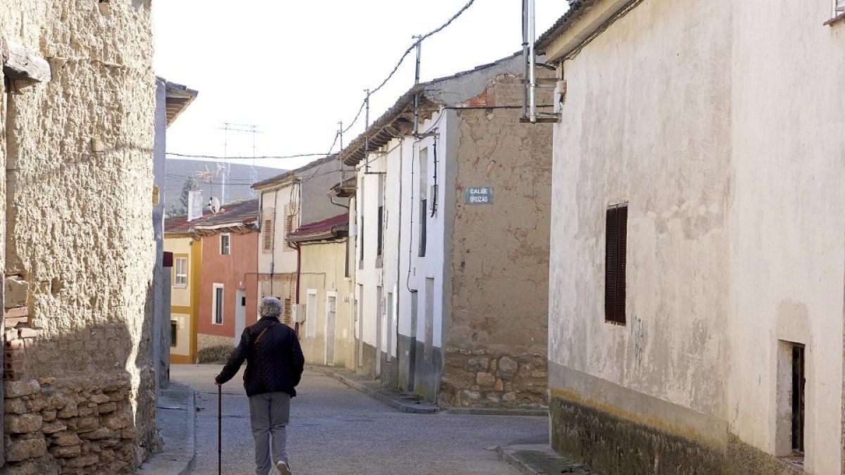 Una mujer camina por la calle de un pueblo de Valladolid
