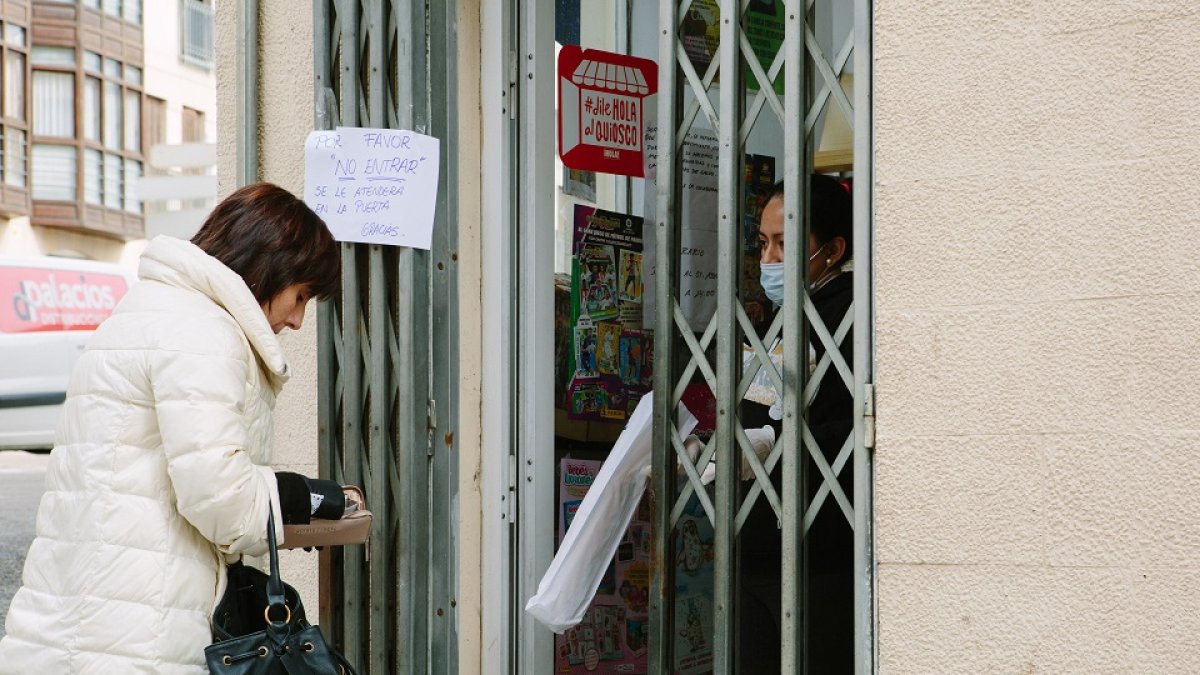 Crisis del coronavirus en Soria. La propietaria de una tienda atiende a sus clientes en la puerta. - ICAL