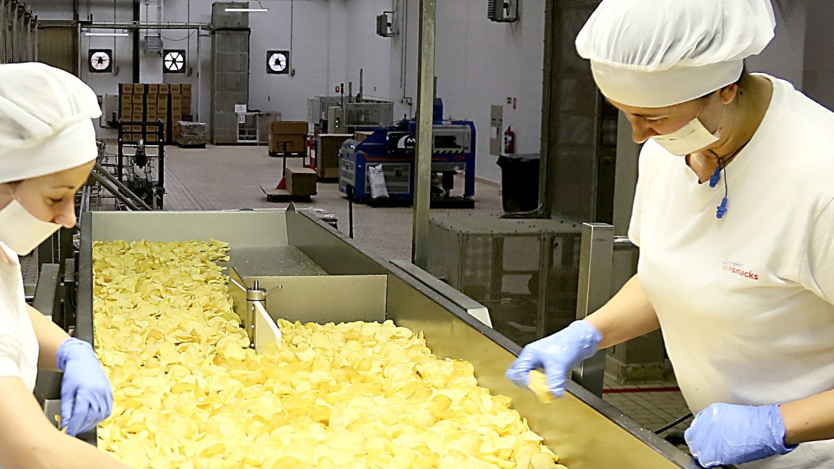 Dos operarias vigilan la calidad de las patatas fritas en las instalaciones de Ibersnacks en Medina del Campo.- ICAL