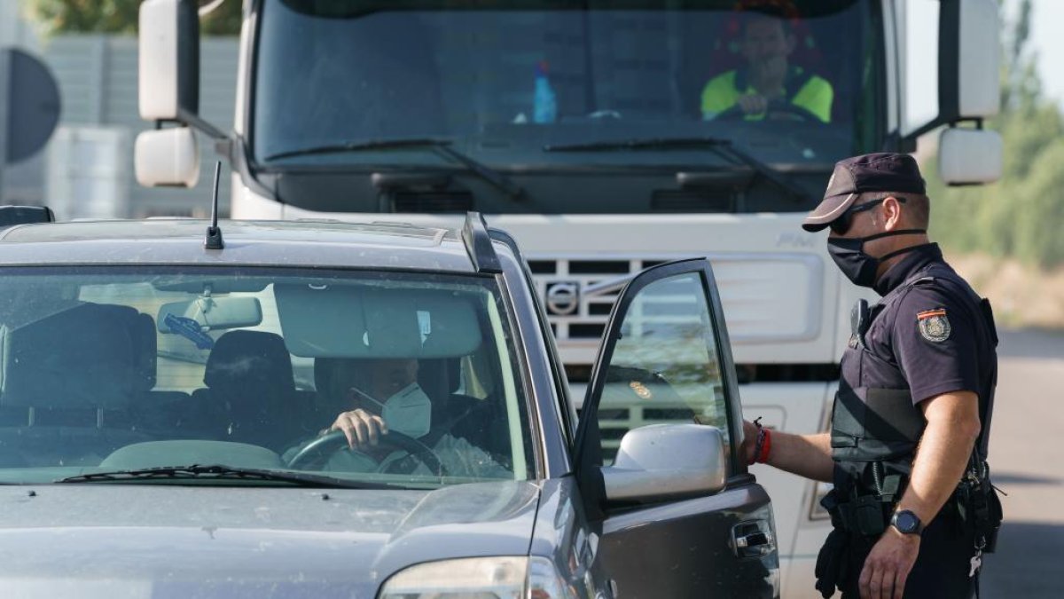 Un policía controla la circulación de personas en el municipio burgalés de Aranda de Duero, confinado por la incidencia de casos de coronavirus. - CESAR MANSO / AFP