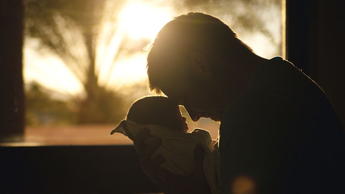 Un padre acaricia con la frente a su hija recién nacida. PQS / CCO