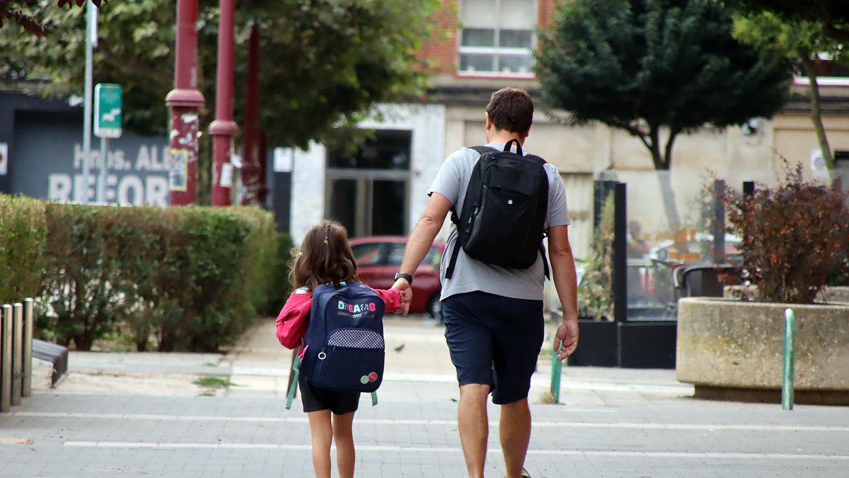Un padre lleva a su hija al colegio.-E. M.