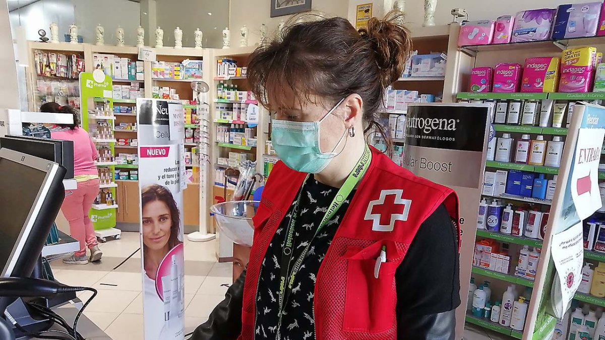 Una voluntaria adquiere medicamentos en una farmacia durante el dispositivo de apoyo habilitado durante la Covid.