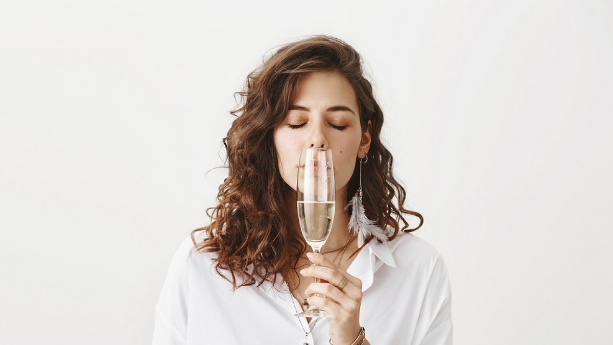 Una mujer enferma trata de oler una copa de vino. / EL MUNDO