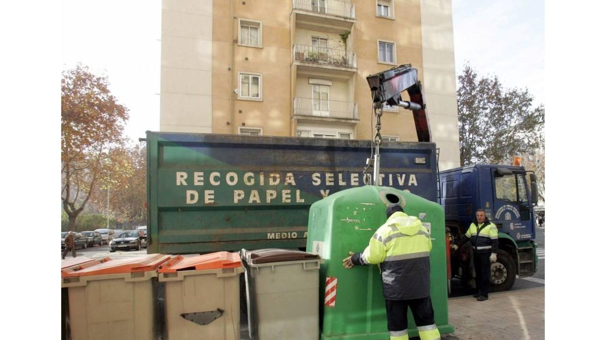 Operarios trabajando en la recogida selectiva del reciclaje de papel y vidrio.- Ical