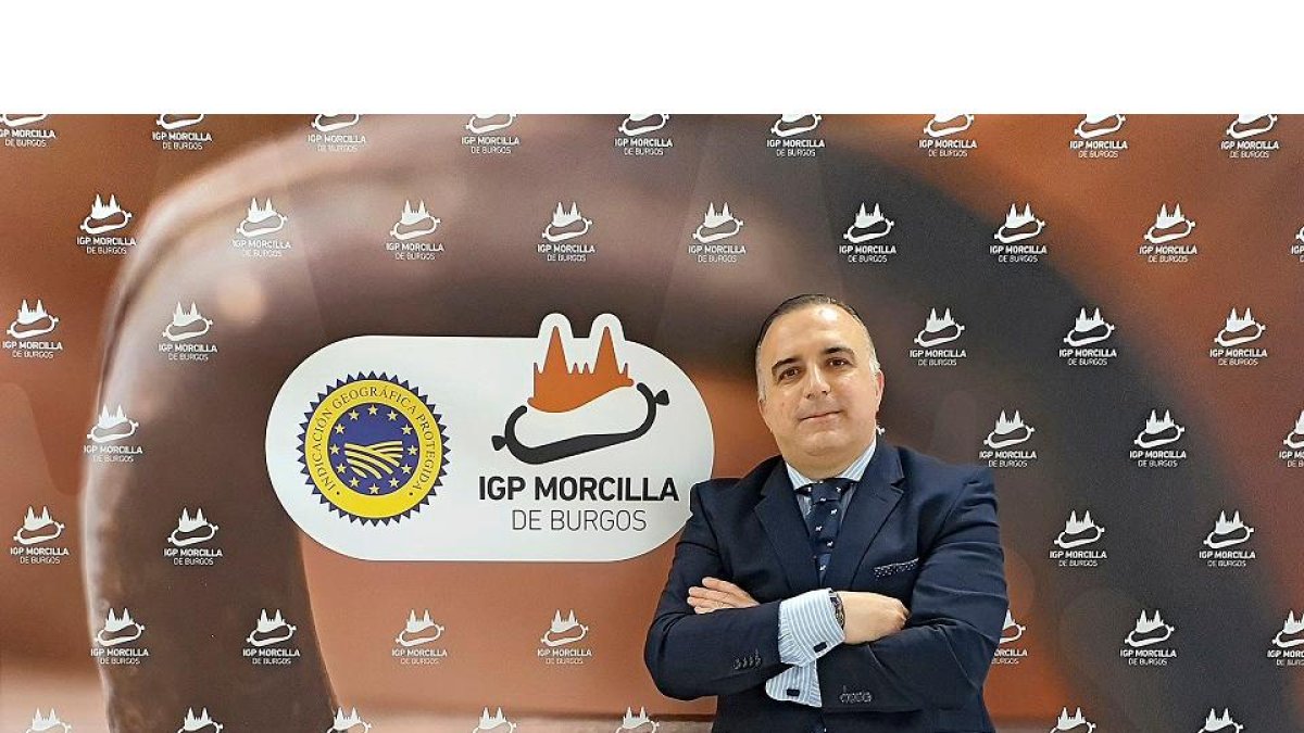 Rafael González, director general de la IGP Morcilla de Burgos, posa frente al sello de la marca de calidad./ ArgiComunicación