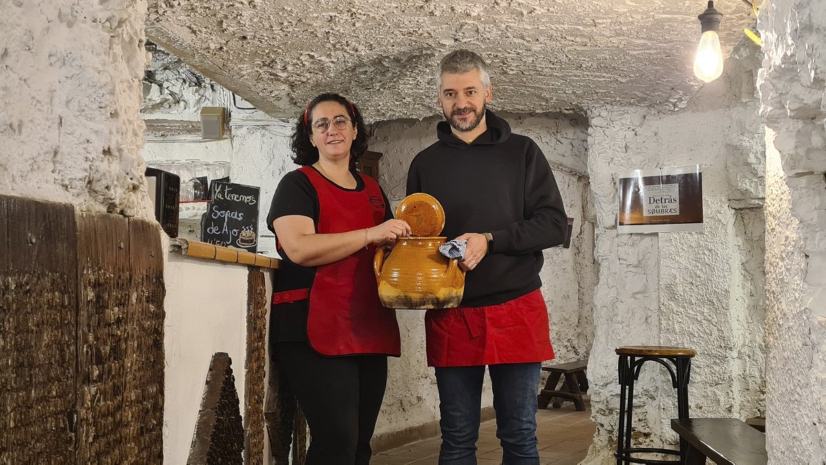 Susana García y Rubén Renedo, en el interior de la bodega, con un puchero de sopas de ajo.- LA POSADA