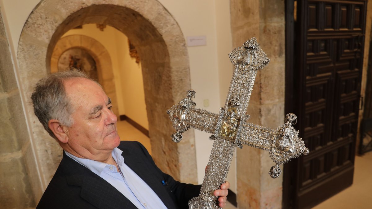 El delegado de Patrimonio Cultural de la Diócesis de Palencia sujeta la cruz procesional