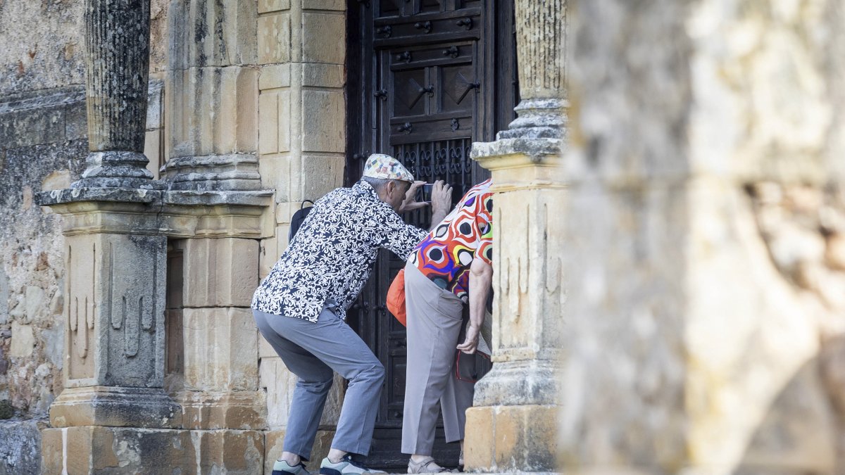 Dos personas sacan una foto del interior del templo cerrado