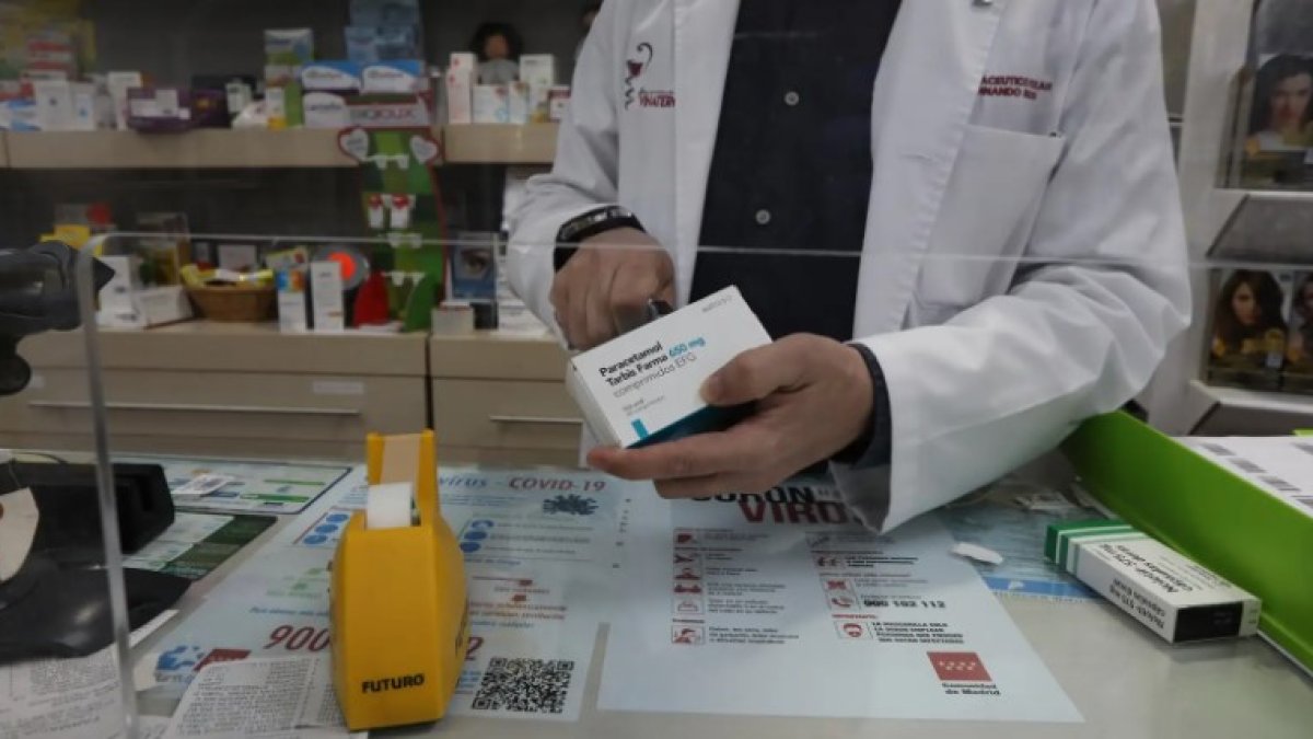 Un farmacéutico con una caja de Paracetamol en su farmacia