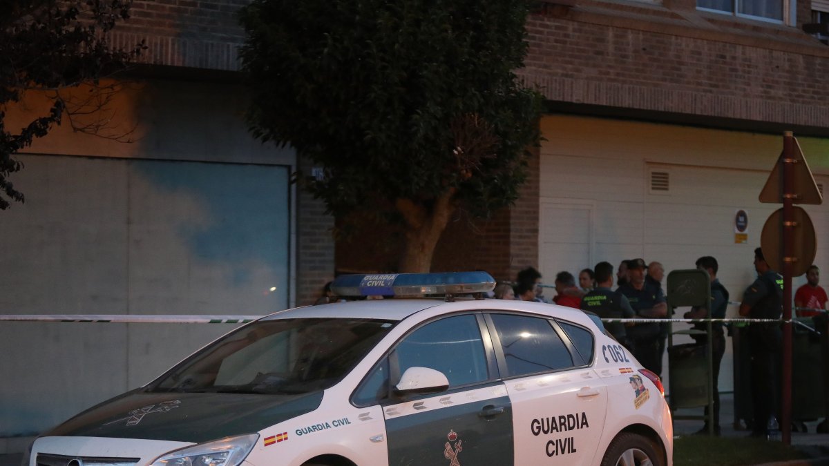 Guardias civiles delante del portal del inmueble donde una mujer ha sido apuñalada en Venta de Baños (Palencia) tras una discusión familiar.