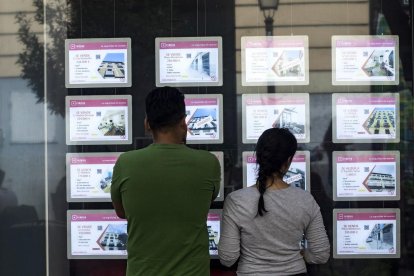 Una pareja de jóvenes ven anuncios de una inmobiliaria.- JAVI MARTÍNEZ