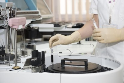 Una persona trabaja con tubos de ensayo en un laboratorio.