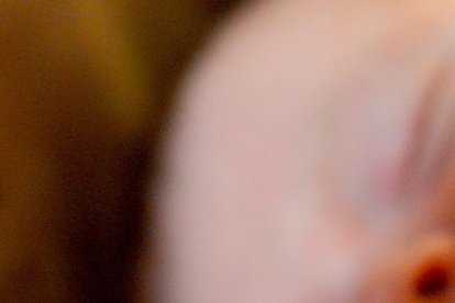 Un bebé agarra el dedo de su madre mientras duerme en su cuna. PQS / CCO