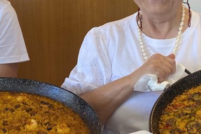 Eva Munera y Laura Fernández con dos paellas antes de servir a la mesa en el restaurante Villa Mencía en Corullón. /