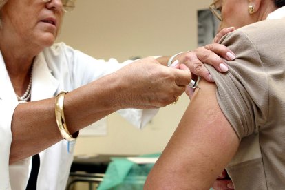 Una persona mayor se vacuna contra la gripe en su centro de salud