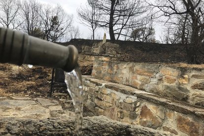 Un caño emana agua a la salida de Otero de Bodas, uno de los pueblos más afectados por el incendio.- E. M.