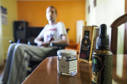 El joven vallisoletano Rubén, con un aceite de cannabis que toma para paliar los dolores que le provoca la Esclerosis Lateral Amiotrófica que padece. MIGUEL ÁNGEL SANTOS (PHOTOGENIC)