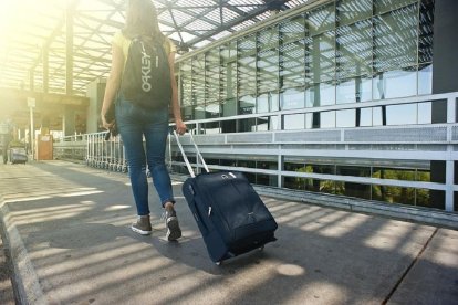 Una joven lleva su maleta en un aeropuerto.- E.M.