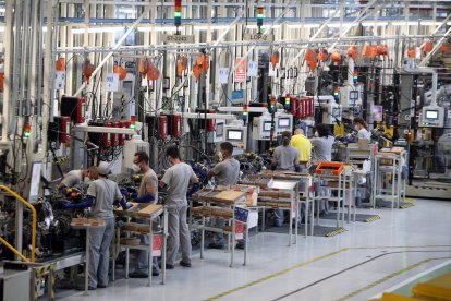 Trabajadores en una línea de trabajo de una industria automovilística | ICAL