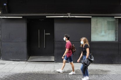 Dos personas pasan por delante de Tintín Club en la plaza de Martí y Monsó de Valladolid. J.M. LOSTAU