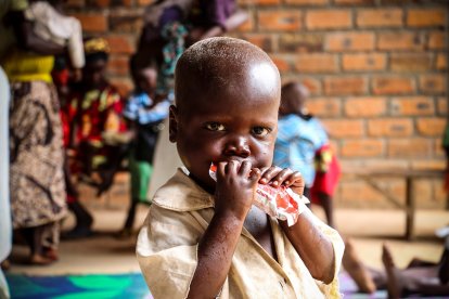 Un niño toma un sobre de alimento terapéutico.- E.M.