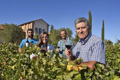 Moisés Gamazo en primer plano, seguido de Esther Pérez, Jesús Herranz y Víctor en el viñedo que está delante de la fachada de la bodega.