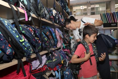 Un joven alumno se prueba una mochila para el nuevo curso escolar en una librería de la ciudad.- ICAL