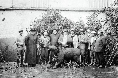 El párroco y el juez municipal, entre otros socios del coto, con un oso pardo abatido.