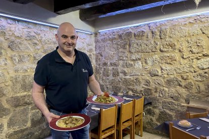 Alberto Beltrán, con una ración de patatas a la importancia y otra de menestra, en el comedor del restaurante Maño.- E.M.