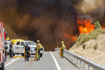 Efectivos de los bomberos de Segovia, de la Junta de Castilla y León y Protección Civil trabajan en la extinción del incendio en la Nacional-110.- ICAL