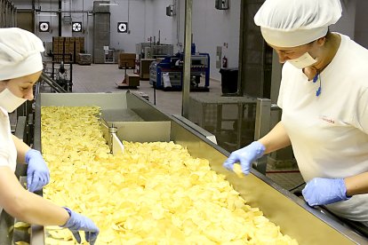 Dos operarias vigilan la calidad de las patatas fritas en las instalaciones de Ibersnacks en Medina del Campo.- ICAL