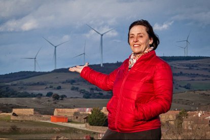 Felicidad Gómez con los aerogeneradores al fondo. MARIO TEJEDOR