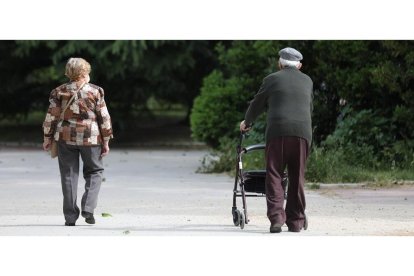 Una mujer y un hombre de edad avanzada pasen por la calle.- E. PRESS