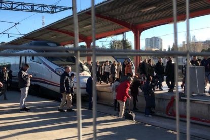 Pasajeros de Renfe cruzando las vías de Chamartín al bajarse del tren.- E. M.