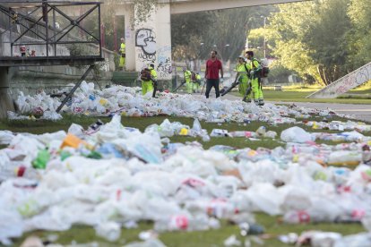 Operarios del servicio de limpieza del Ayuntamiento de León, retiran la basura acumulada en la orilla del Río Bernesga de la capital leonesa tras la noche de San Juan.- ICAL