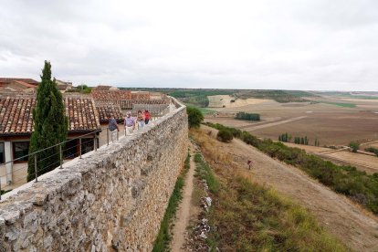 Un grupo de turistas recorre la muralla de la localidad vallisoletana de Urueña. - ICAL