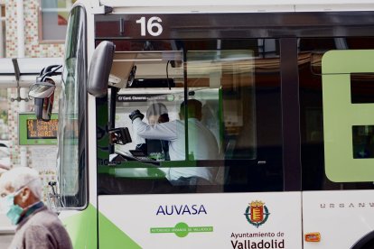 Un conductor de autobús ofrece una mascarilla a un pasajero. ICAL