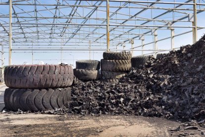 Close up of old used tires and shredded tire pile in background