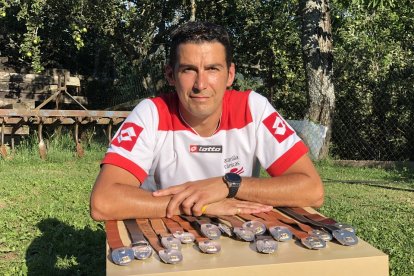 Héctor García, junto a parte de sus medallas en el jardín de su casa de Campohermoso./ ARGICOMUNICACIÓN