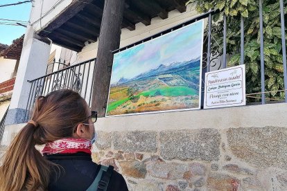 Una turista contempla uno de los cuadros que cuelgan de las calles de al localidad. / LA POSADA.