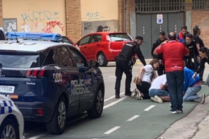 Unos jóvenes atienden al aficionado donostiarra en presencia de la Policía.- HDS