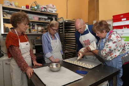 Las voluntarias María Antonia Rodríguez(3I), Eva Burón(I), Rosario Minguez(4D) ; y la coordinadora del voluntariado, Cecilia Presa(3D), junto a usurarios de Hermanas Hospitalarias tras finalizar el taller de pastelería en la La Casa del Pan Ayuela Burón