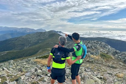 Dos montañeros disfrutando de la panorámica de cumbres.