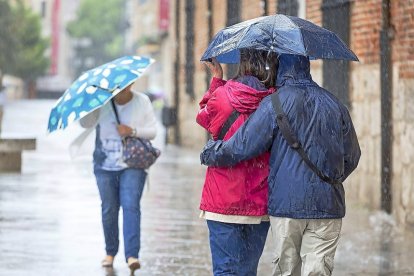 Viandantes pasean bajo la lluvia en una fotografía de archivo.