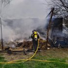 Bombero tratando de extinguir el incendio de una nave en Albares de la Ribera, León. -ICAL