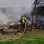 Bombero tratando de extinguir el incendio de una nave en Albares de la Ribera, León. -ICAL