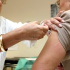 Una persona mayor se vacuna contra la gripe en su centro de salud